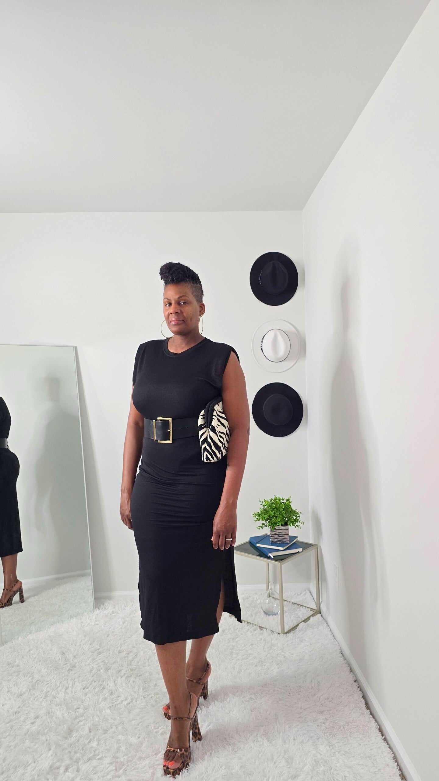 Sleeveless dress with padded shoulders and a crew neck, crafted from a blend of 50% viscose and 50% polyamide. Features include slit sides for enhanced movement and a sleek, modern look. The dress is shown in a large size, emphasizing its comfortable and structured fit. Note: belt not included. Suitable for both formal and casual occasion