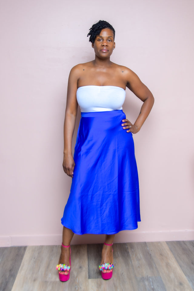 Royal Satin A-Line Midi Skirt: Elegant and Versatile  Elevate your wardrobe with our Royal Satin A-Line Midi Skirt. This stunning piece, available in a rich royal blue, features a luxurious satin finish and a flattering A-line silhouette that falls gracefully to midi length. The wide elastic band ensures a comfortable and secure fit, making it a versatile addition to your collection.  Key Details: Available in Royal Midi Length Satin Skirt A-Line Silhouette Wide Elastic Band 100% Polyester Model Details: