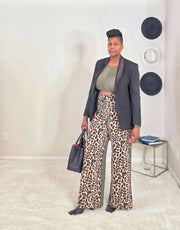Person wearing a black blazer and leopard print pants in an indoor setting.
