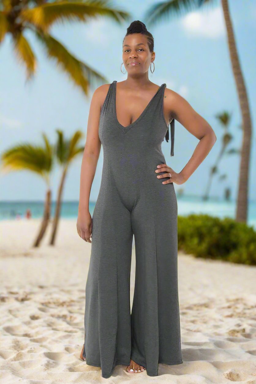 Charcoal Tie Strap Jumpsuit: A stylish and comfortable jumpsuit featuring adjustable tie straps, a deep V-neckline, and a wide-leg design with pleated detailing. Made from a blend of polyester, rayon, and spandex, it offers stretch and durability for everyday wear.

