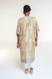Available in Grey Damask Print  Elevate your style with our beautifully crafted kimono, available in a stunning denim damask print. This versatile piece is perfect for any occasion, blending elegance with casual charm.  Key Features:  Split Angel Sleeves: Add a touch of sophistication and flowy elegance with our unique split angel sleeves. Mini Pom Pom Accent: Delicate mini pom pom accents along the edges provide a playful yet chic detail. 100% Viscose: