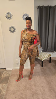Women's leopard print two-piece set featuring an asymmetrical one-shoulder top with tie detail and matching high-waisted capri pants. Bold, stretchy, and figure-flattering—perfect for a confident, fashion-forward look.