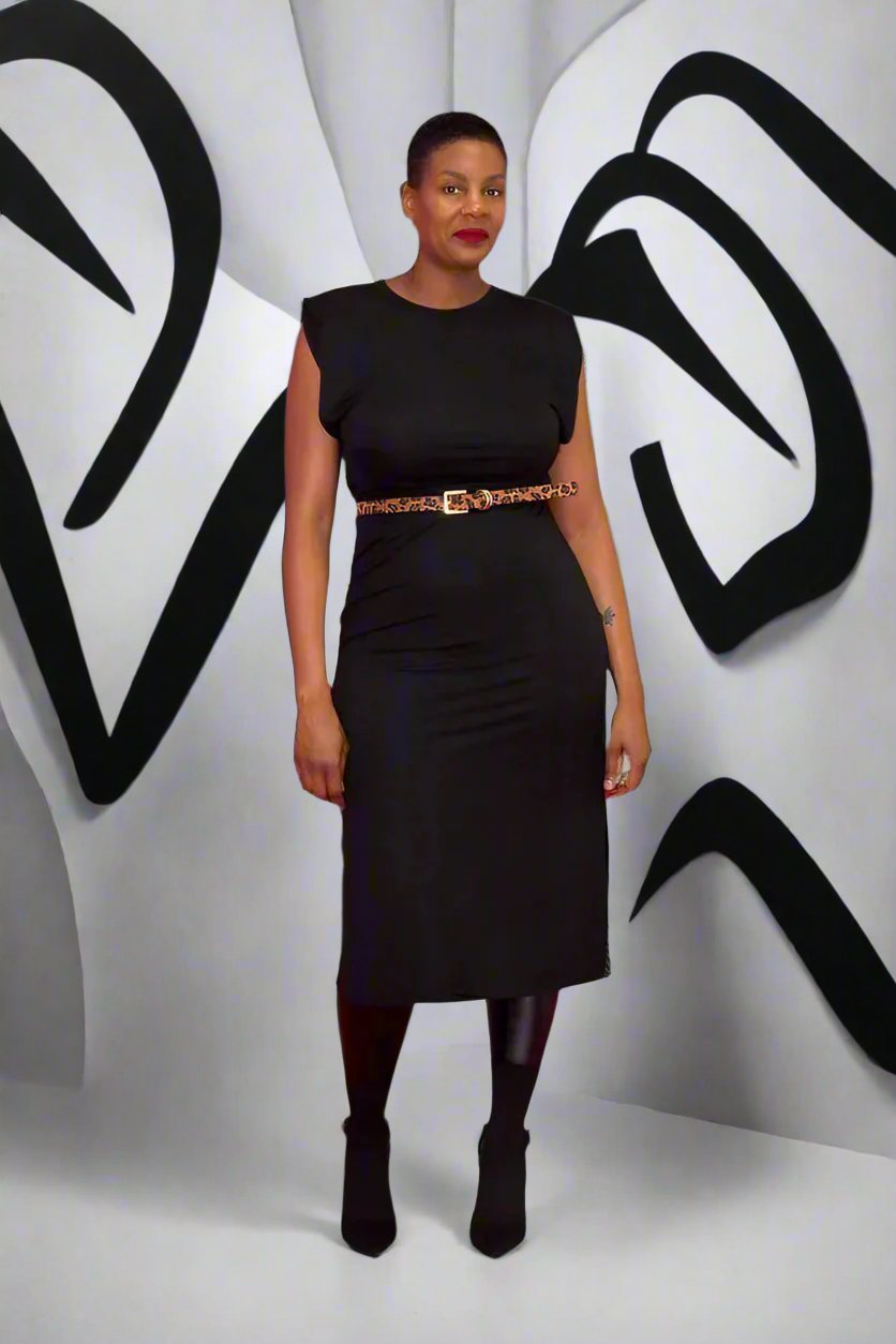 Sleeveless dress with padded shoulders and a crew neck, crafted from a blend of 50% viscose and 50% polyamide. Features include slit sides for enhanced movement and a sleek, modern look. The dress is shown in a large size, emphasizing its comfortable and structured fit. Note: belt not included. Suitable for both formal and casual occasion