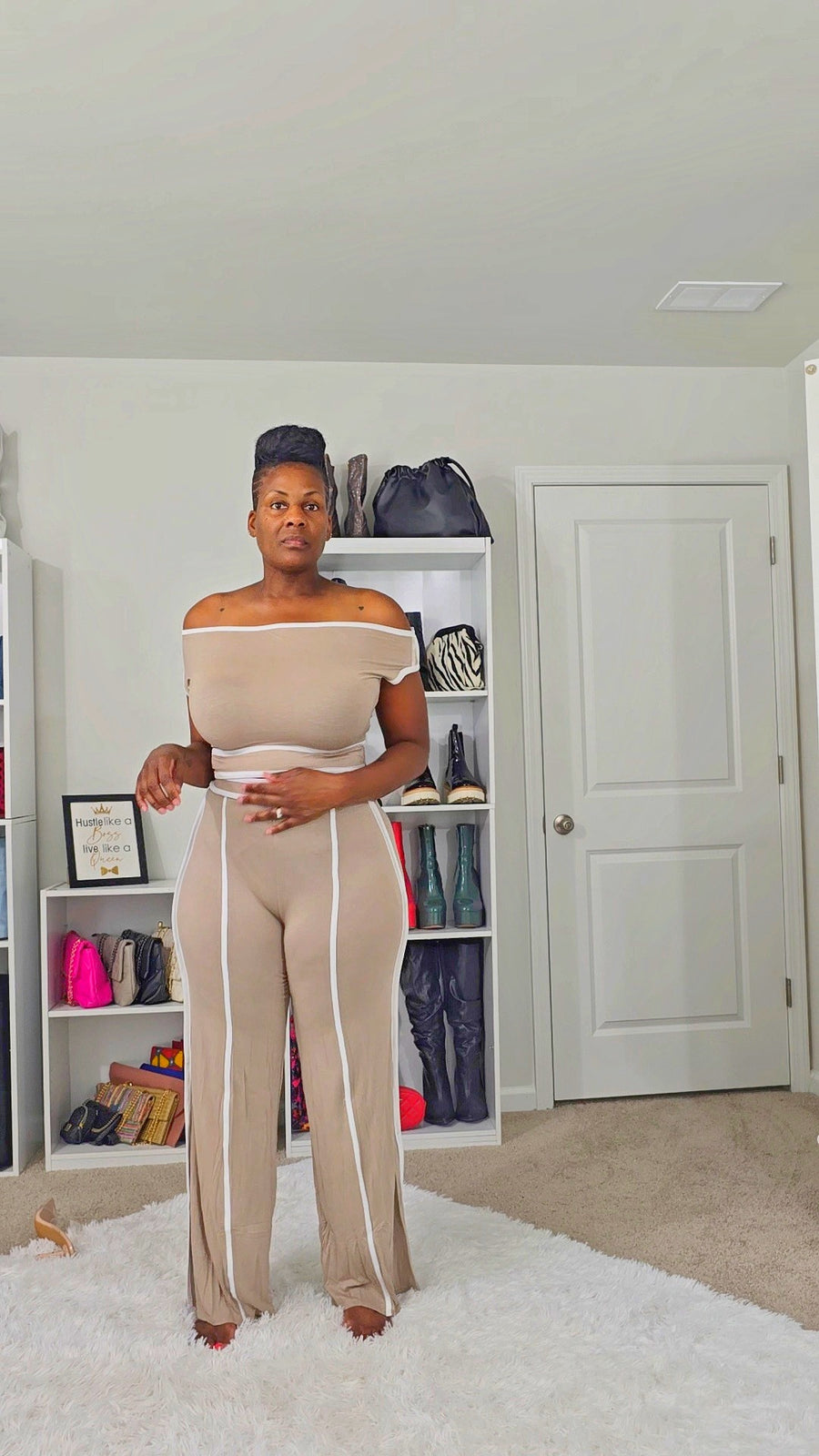 Woman wearing an off-shoulder short sleeve color contrast top with matching wide leg pull-up pants, made of stretch rayon and polyester, chic two-piece set.