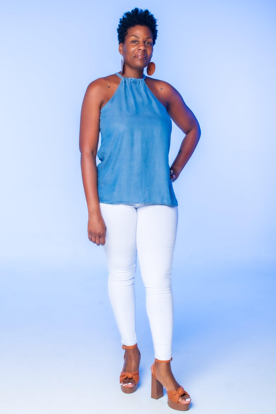 Medium Blue Chambray Halter Top  Discover casual charm with our Medium Blue Chambray Halter Top. This stylish piece features a cinched neckline, back keyhole detail, and neckline tie, perfect for effortless chic.  Key Features:  Chambray fabric Halter style Cinched neckline Back keyhole detail Neckline tie Ideal for pairing with jeans or shorts for a laid-back yet fashionable look